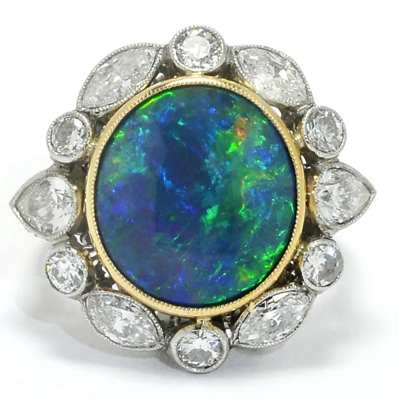 Ring with a large central opal stone surrounded by smaller diamonds on a white background